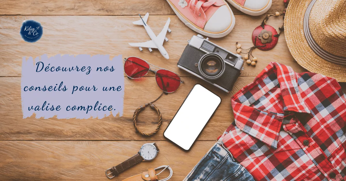 Objets de voyage sur fond bois pour une valise complice : lunettes, caméra, chapeau et message doux – ambiance romantique et vintage du voyage de noces